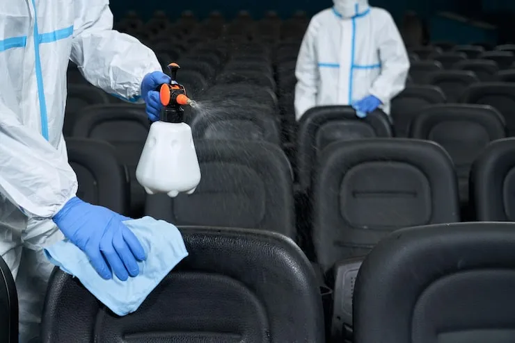 workers-cleaning-chairs-with-disinfectants-cinema_7502-9508